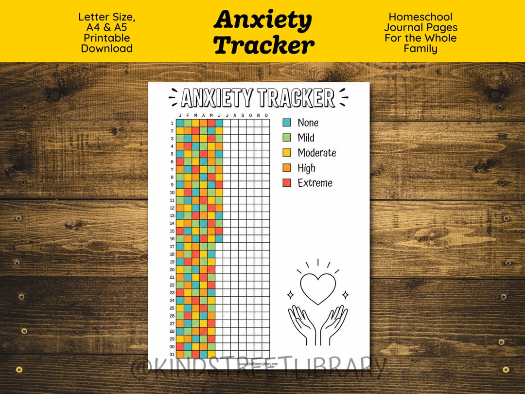 The 'Anxiety Tracker' printable on a wooden table: a year-at-a-glance grid of days 1-31 across twelve months, partly colored in, with a five-level key from None to Extreme and a heart-in-hands doodle