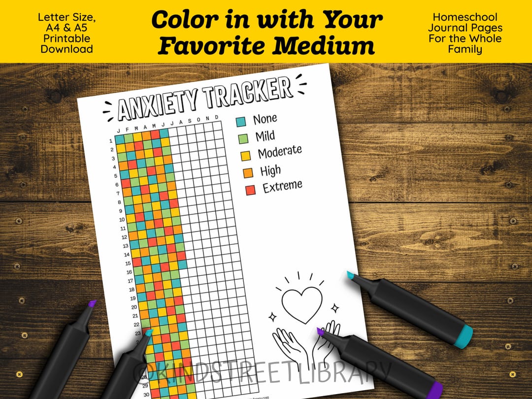 The 'Anxiety Tracker' grid partly filled in its five legend colors, laid on a wooden table among chunky markers, under the banner 'Color in with Your Favorite Medium'